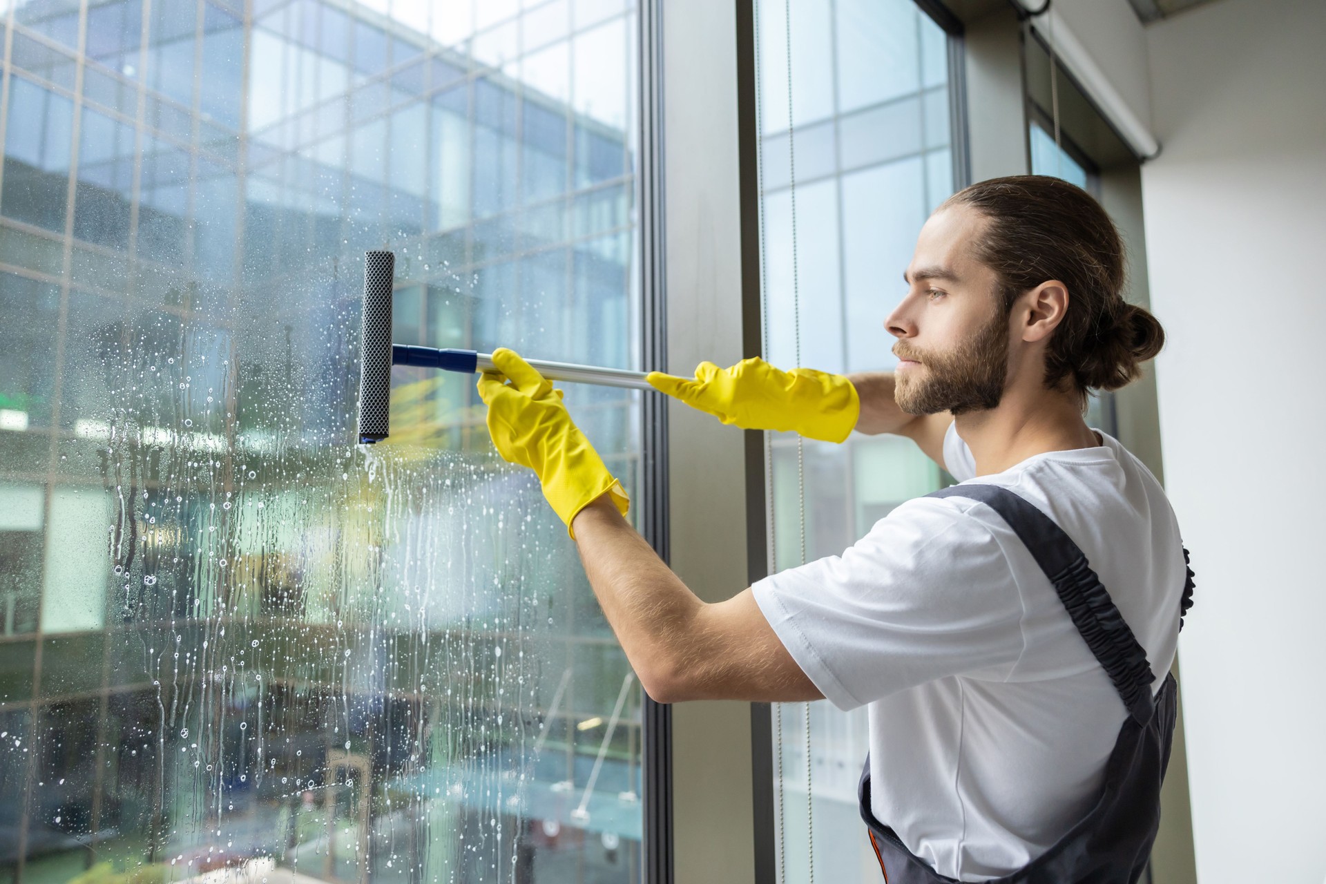 Cleaning person looking busy while cleaning the windows in the office