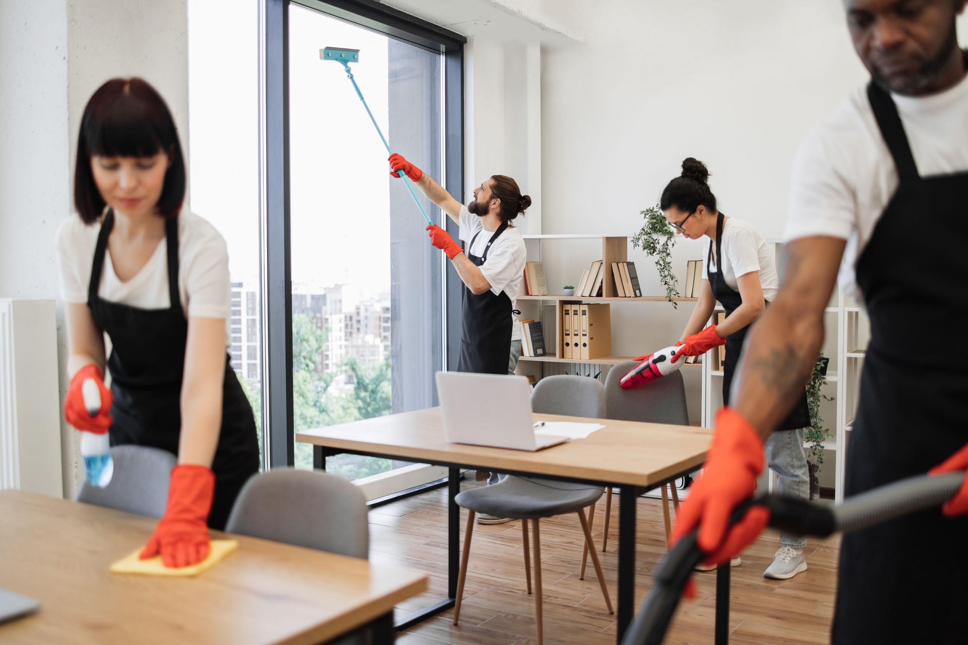 People of cleaning service cleans tables, floor, and panoramic windows.